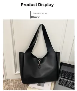 Detail of black large capacity hobo bag with gold metal hook clasp in office setting