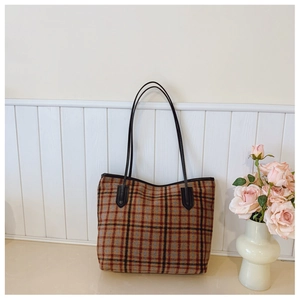 Sac cabas à carreaux vintage avec lanières en cuir noir dans un cadre de vie moderne