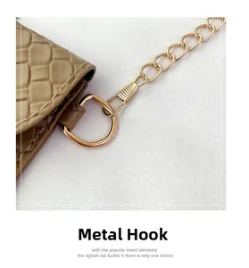 Macro shot of gold metal hardware and weave pattern on the khaki cross-body bag