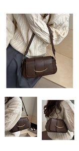 Detailed view of dark brown croc-pattern leather bag with elegant gold curved metal buckle