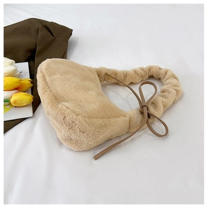 Detail of plush shoulder bag featuring beige faux fur, ruffled handle and leather bow