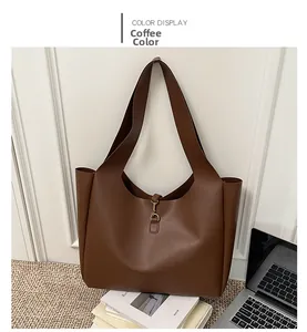 Detail of coffee brown tote bag with metal hook closure in a stylish office setting