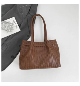 Close-up of the retro V-pattern woven texture on a large brown commuter tote bag