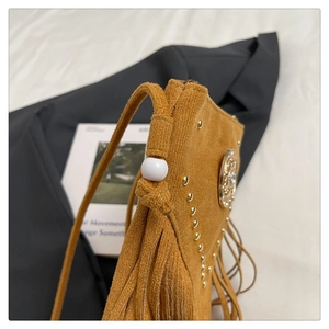 Détails du sac besace en daim jaune avec franges, rivets et boucle métallique décorative