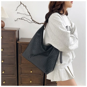 Detail of black woven Hobo shoulder bag showing large capacity and textured checkerboard pattern