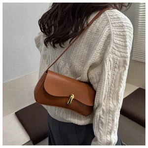 Detail of vintage brown leather shoulder bag with elegant gold rectangular twist lock