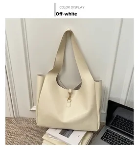 Detailed view of the cream white tote bag featuring a decorative gold spring buckle