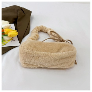 Detailed view of beige plush shoulder bag featuring soft faux fur texture and bow detail