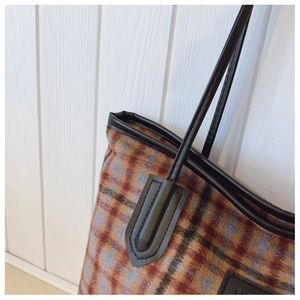 Détail du sac cabas à carreaux vintage en tweed avec coutures en cuir noir renforcées