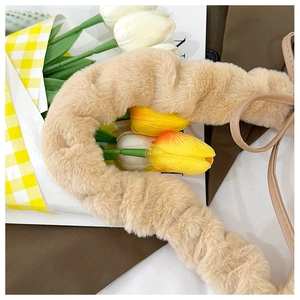 Detail of plush faux fur scrunchie handle strap for bags in soft beige color