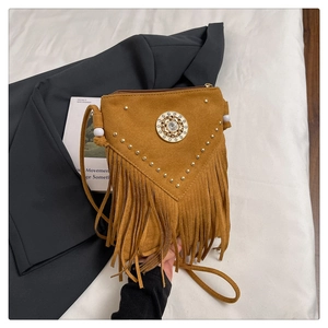 Détail du sac bandoulière en daim marron avec franges bohèmes et rivets métalliques