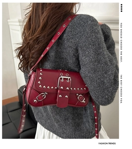 Dettaglio borsa punk in pelle rossa con borchie argentate e tracolla metallica regolabile