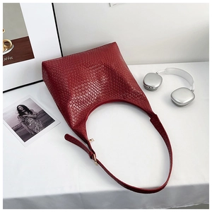 Detail of burgundy crocodile pattern hobo bag showing texture and adjustable strap