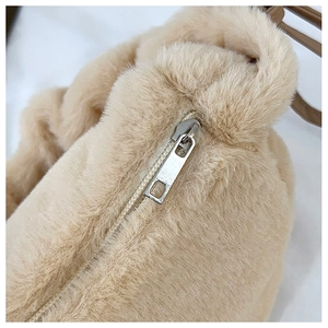 Close-up of beige faux fur texture and silver metal zipper on minimalist plush bag