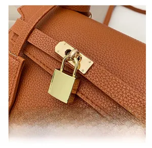 Close-up of golden square padlock hardware and textured brown litchi grain leather