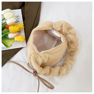 Detail of beige plush shoulder bag featuring a scrunchie handle and zipper closure