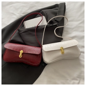 Detail of elegant crocodile-pattern leather handbags with vintage gold metal buckles
