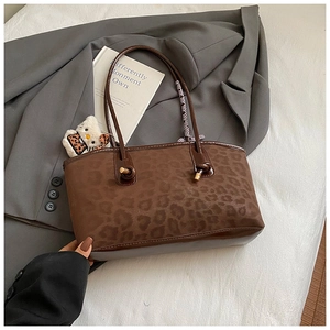 Dettaglio della borsa tote leopardata con base in pelle marrone e nodo sul manico