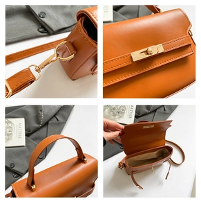Detail view of brown faux leather handbag showing golden hardware and turn-lock closure
