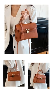 Detailed close-up of brown litchi pattern leather Kelly bag with gold lock and strap