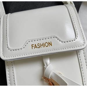 Detailed close-up of white textured PU leather bag with golden fashion letter print