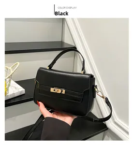 Detail view of the black leather Kelly bag with golden turn-lock and detachable strap