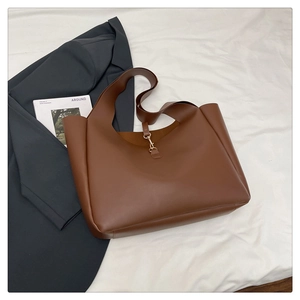 Vista dall'alto di una grande borsa tote in pelle marrone con tracolla e gancio d'oro