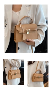 Detail view of brown pebbled leather texture and gold padlock on luxury handbag
