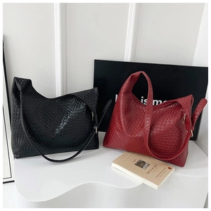 Detail of woven texture tote bags in black and dark red colors with golden zipper accents