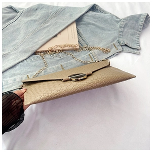 Detail of beige woven crossbody bag with gold chain and circular metallic buckle