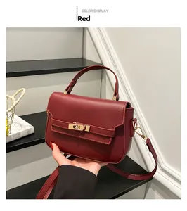 Close-up of wine red leather handbag with gold twist lock and metal hardware details