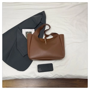 Dettaglio della grande borsa tote in pelle marrone scuro con chiusura in metallo dorato
