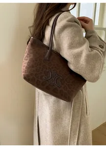Detail of leopard print tote bag featuring a metallic C logo and suede-like texture