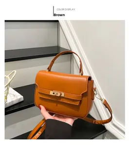 Close-up of brown textured leather mini bag featuring golden twist lock and top handle