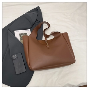 Dettaglio borsa tote in pelle marrone con chiusura metallica e stile professionale