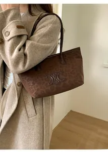 Detail of leopard print tote bag featuring embossed logo and premium suede texture
