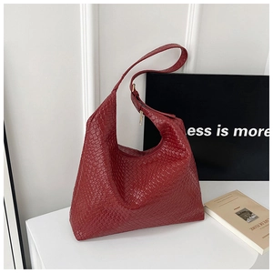 Detail of red woven leather hobo bag with gold zipper and wide shoulder strap
