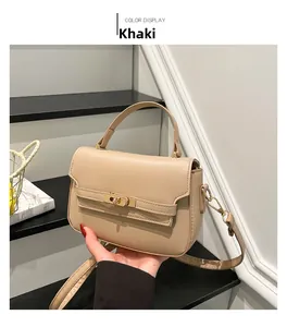 Detail view of khaki crossbody bag with golden rotary lock and decorative strap