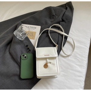 Chic white leather crossbody bag detail with golden FASHION text and elegant metal charm