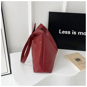 Detail of burgundy woven texture on a large tote bag with a modern minimalist aesthetic