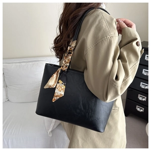Détail d'un sac cabas noir avec foulard décoratif en soie et surpiqûres blanches contrastées
