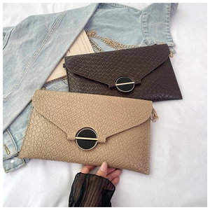 Close-up of elegant envelope chain bags with quilted and crocodile textures and gold clasp