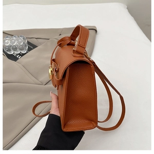 Detail of brown lychee grain leather mini backpack with elegant gold twist lock closure
