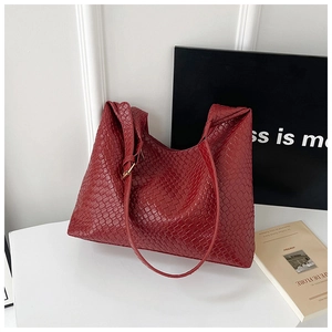 Detail of burgundy woven tote bag showing adjustable gold metal buckle and texture