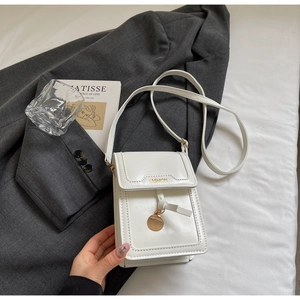 Detail of white PU leather mini crossbody bag with gold metal plate and ribbon decoration