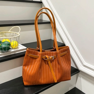 Orange-brown woven texture tote bag with long shoulder straps and metallic buckle detail