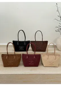Detailed view of large tote bags in leopard print with five colors on stone steps