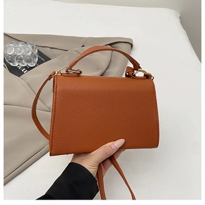 Close-up of caramel lychee pattern leather tote bag with gold buckle and handle