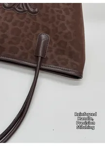 Detail view of reinforced stitching and brown leopard print suede on the bucket bag