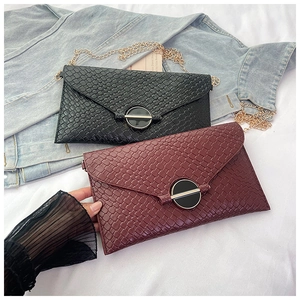 Detail of woven texture cross-body bags in burgundy and black with gold round buckles